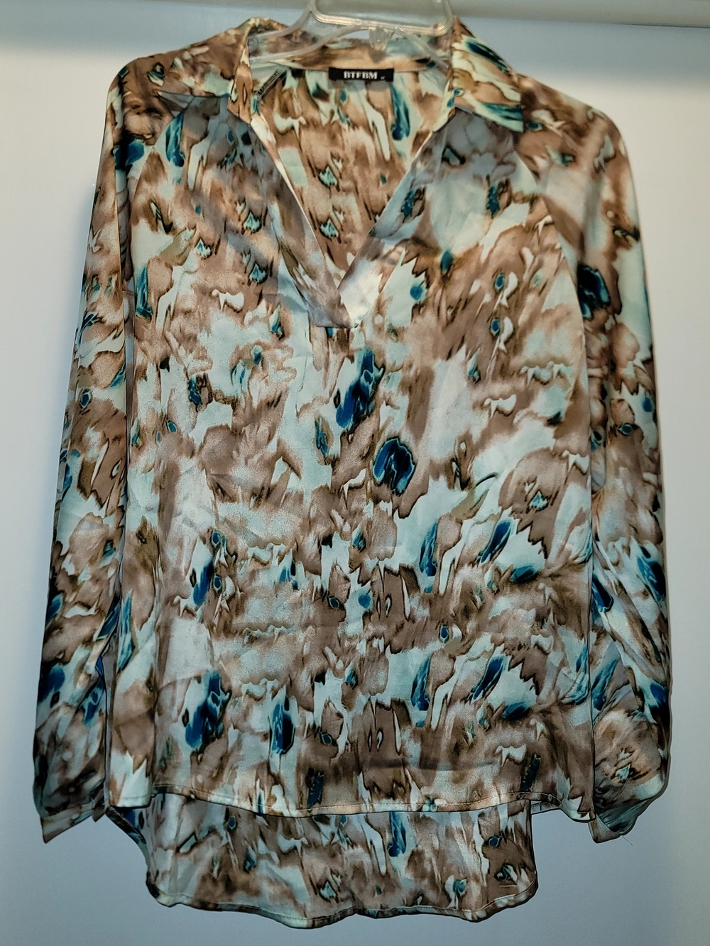 BTFBM blouse features a brown and blue abstract print with a V-neckline